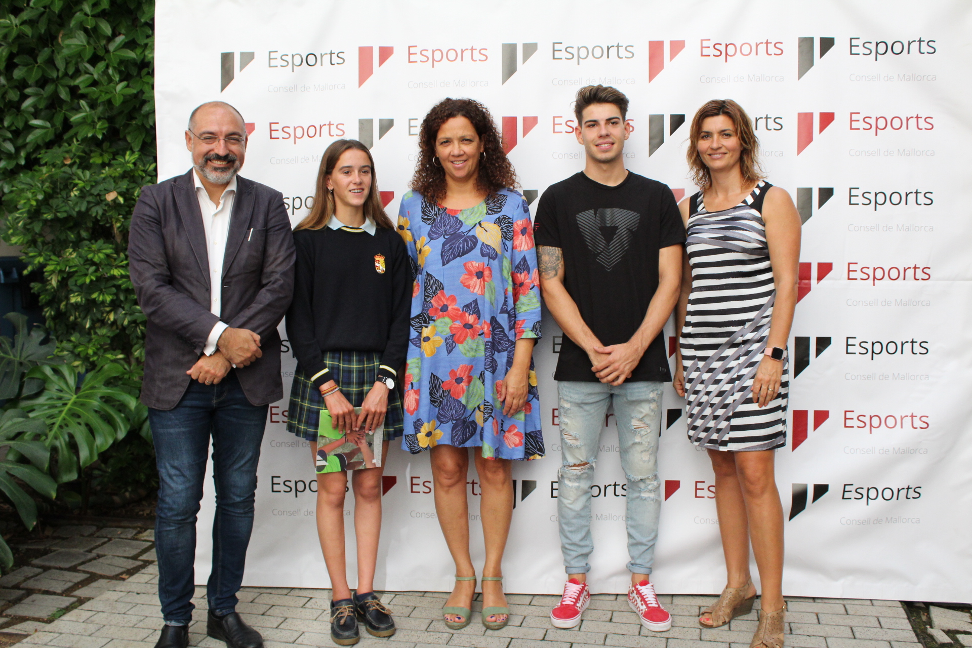 La presidenta Catalina Cladera, el conseller Andreu Serra i la directora insular Marga Portells amb els joves esportistes d'elit, Maria Perelló i Augusto Fernández