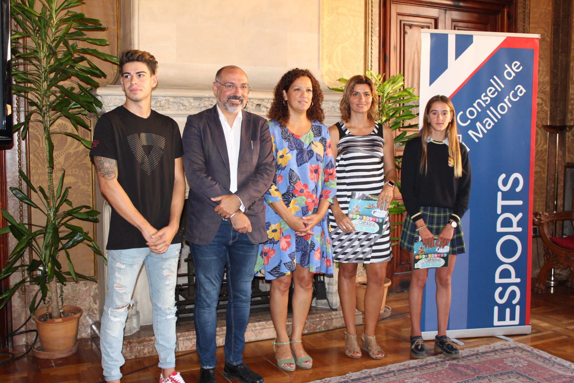 La presidenta Catalina Cladera, el conseller Andreu Serra i la directora insular Marga Portells amb els joves esportistes d'elit, Maria Perelló i Augusto Fernández